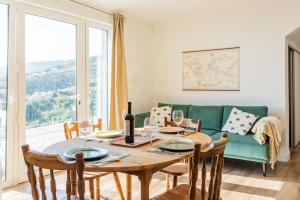 een eetkamer met een tafel en een groene bank bij Cantinho do Barreiro - Calheta in Calheta
