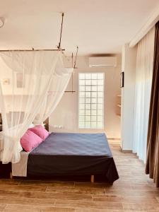 a bedroom with a bed with a mosquito net at Family Tree - WATER Available - SELF check in in Golem