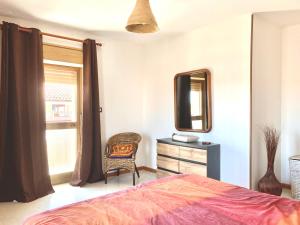 a bedroom with a bed and a mirror and a chair at Soggiorno a Giannài in Macomer +2 photos