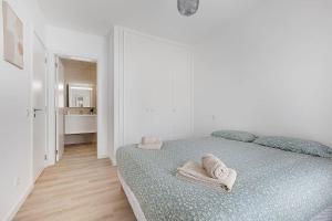 ein weißes Schlafzimmer mit einem Bett mit Handtüchern darauf in der Unterkunft 13 Esteva Resorts 1ºC Aljezur 5 min to the Beach in Aljezur