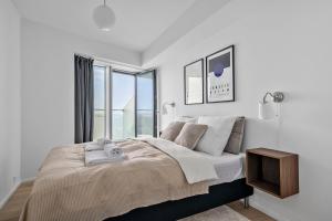 a white bedroom with a large bed with a window at Penthouse suite on 35th floor in Aarhus