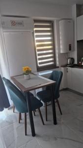 a kitchen with a wooden table and two blue chairs at Raul Studio in Saturn +9 photos