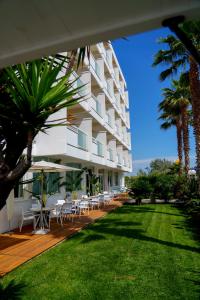 a building with chairs and tables on a lawn at Hotel Belvedere in Martinsicuro