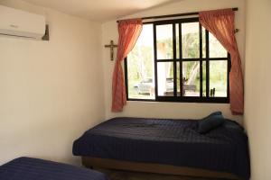 a bedroom with a bed and a window at El Prado- Casa Maya y Casa Rancho-10 personas in Hoctún