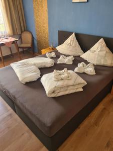 a bed with white sheets and pillows on it at Zum Feti Pension und Restaurant in Rüdesheim am Rhein +9 photos