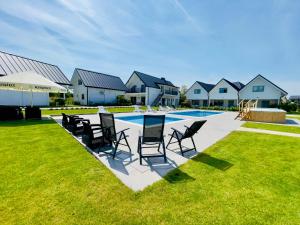 a group of chairs sitting next to a swimming pool at New Corner Holiday Camp in Niechorze