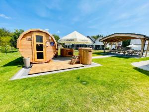 a large wooden cabin in a grass field at New Corner Holiday Camp in Niechorze