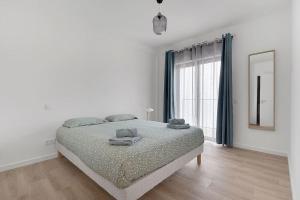 ein Schlafzimmer mit einem Bett und einem großen Fenster in der Unterkunft 13 Esteva Resorts 2ºE Aljezur 5 min to the Beach in Aljezur