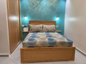 Un dormitorio con una cama con una pared azul. en Superbe Studio vue piscine, en Tánger 14 fotos más