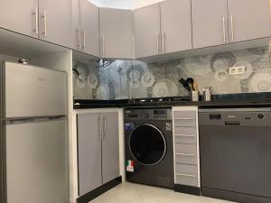 cocina con lavadora y armarios blancos en Superbe Studio vue piscine, en Tánger
