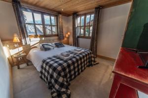 a bedroom with a bed in a room with windows at Chalet Familial Meribel 1600 in Les Allues