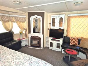 a bedroom with a bed and a tv and a fireplace at Vila Giruliai in Klaipėda