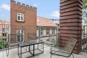 a group of chairs and a table on a balcony at Inner City Nest in Aarhus