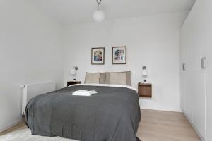 a bedroom with a bed and two pictures on the wall at Inner City Nest in Aarhus