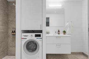 a white laundry room with a washing machine at Spacious 2BR Inner City Apartment for 6 People in Aarhus