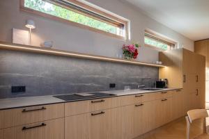 a kitchen with wooden cabinets and a chalkboard wall at 50 meters to the Sea in Juodkrantė +92 photos