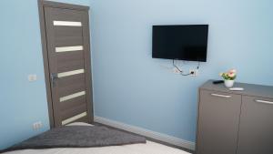 a bedroom with a bed and a tv on a wall at FRATU Apartment in Făgăraş