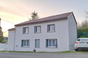 a white house with a car parked in front of it at maison de Village Médiéval 7 personnes in Lauzerte