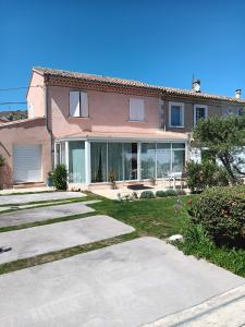 ein großes rosa Haus mit Glastüren und einem Hof in der Unterkunft La villa MARIE in Cavaillon
