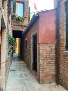 an alley with a brick building and a door at Casa Giardini in Venice