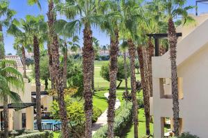 Blick auf ein Resort mit Palmen in der Unterkunft Two Bedroom Penthouse Apartment In Roda Golf in Los Cortados