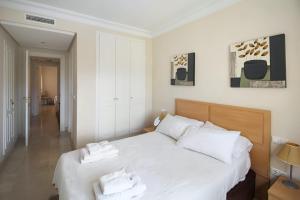 ein Schlafzimmer mit einem weißen Bett mit Handtüchern darauf in der Unterkunft Two Bedroom Penthouse Apartment In Roda Golf in Los Cortados
