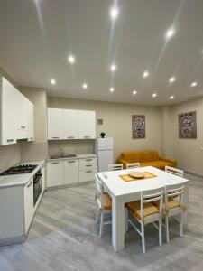 una cucina con tavolo bianco e divano di Le Case del Cavaliere ad Acireale