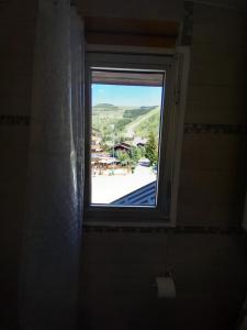 a window in a bathroom with a view of a patio at Le Kandahar Les 2 Alpes in Les Deux Alpes