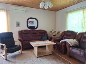 a living room with leather furniture and a table at Sunin Tupa in Rantsila