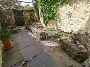 a patio with a table and chairs next to a stone wall at Suffolk House in Narberth +20 photos