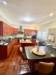a kitchen with wooden cabinets and a table with chairs at French Manor 2 Stellenbosch in Stellenbosch