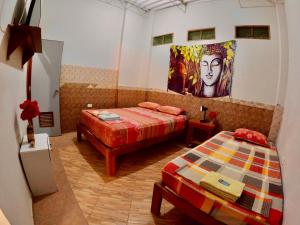 a room with two beds and a painting on the wall at Stone House Mancora in Máncora +31 photos