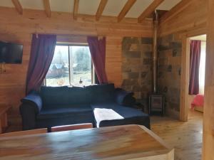 a living room with a couch and a table at Cabañas Jatrima in Liquiñe