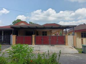 a house with a red gate in front of it at Amin Homestay Taman Kenari Kulim in Kulim