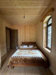 a bed in a room in a wooden house at Chazhashi Guesthouse - Rooms with Private Bathrooms in Ushguli