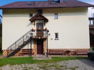 a white house with a staircase on the side of it at Noclegi u Daszyka in Polańczyk