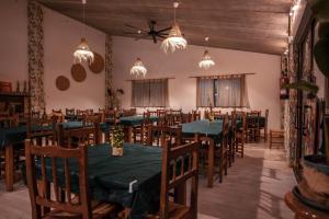 a dining room with green tables and chairs at Slow Life Camping Venta del Moro in Venta del Moro