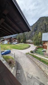 une vue d'une route depuis un bâtiment avec une voiture dans l'établissement Appartamento immerso nel verde zona tranquilla, à Auronzo di Cadore