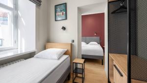 a small room with two beds and a tv at Rija Old Town Hotel in Tallinn