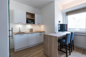 a kitchen with a table and a desk with a computer at Logis H&ocirc;tel Acacia in Esch-sur-Alzette