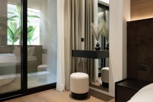 a bedroom with a bed and a stool in front of a mirror at Blanco Athens Aparthotel in Athens