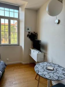 a living room with a table and a tv at 5 - Cosy Studio in Old Antibes in Antibes