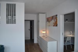 Una habitación blanca con un escritorio y una silla. en Apartment Silesia Park - Free Parking - easy check-in, en Katowice