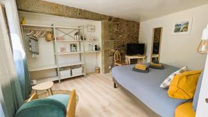 a small living room with a blue bed and a couch at LA GUESTHOUSE - À deux pas du Sentier des Douaniers in Pordic