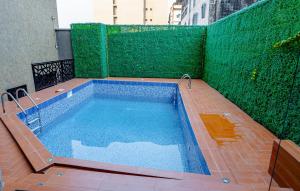 a small swimming pool with a green wall at RESIDENCE ISABELLA in Douala