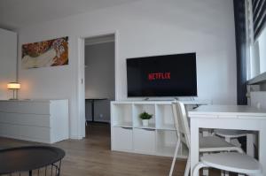 una sala de estar con TV en un armario blanco en Apartment Silesia Park - Free Parking - easy check-in, en Katowice
