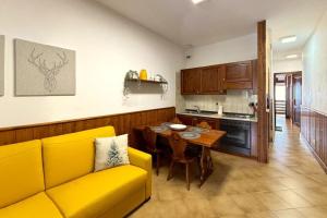 a living room with a yellow couch and a table at The Capriolo home in Tarvisio +11 photos
