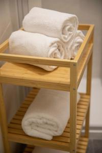 a wooden towel rack with white towels on it at Green rooms in Bari