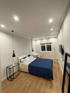 a bedroom with a blue bed in a room at Quarto de casal close to Lisbon Flat equipado in Almada