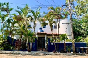 ein blau-weißes Haus mit Palmen davor in der Unterkunft Villa Papaya #2 spacious 2 bedroom beach villa in San Pancho in San Francisco